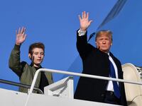 US President Donald Trump and son Barron Trump wave while making their way to board Air Force One at Andrews Airforce Base, Maryland on January 17, 2020.