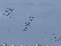 Military cargo plane drops humanitarian aid packages with parachutes over Gaza on March 07, 2024.