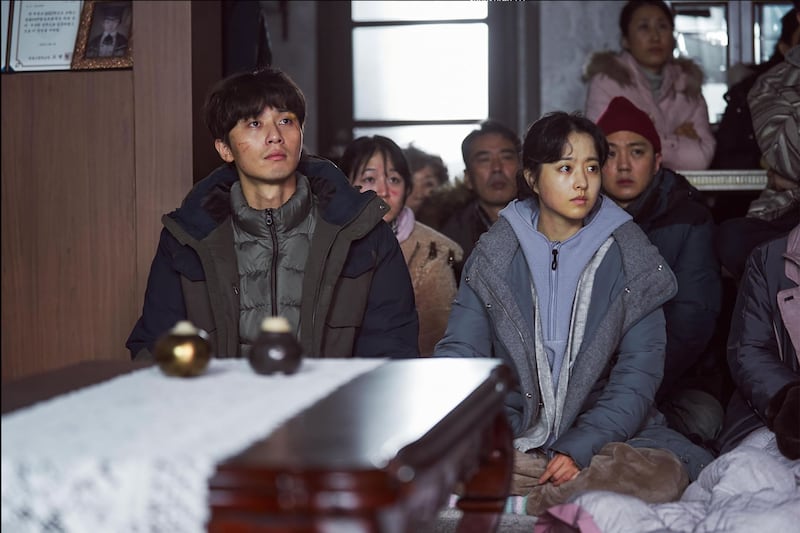 Park Seo-joon and Park Bo-young sit next to each other in a still from 'Concrete Utopia'