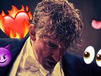 A close up photo of Bradley Cooper as Leonard Bernstein in a conductor’s tuxedo looking down while flirty emojis surround him.