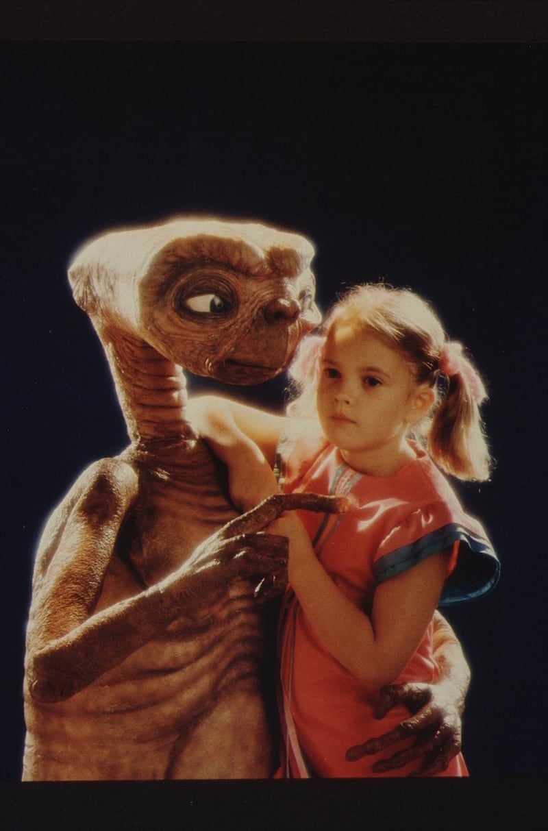 Drew Barrymore poses with E.T. at Carlo Rimbaldi studio in April, 1982 in Los Angeles, California.
