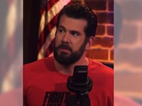 Steven Crowder speaks into a microphone.