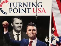 A pile of flowers, candles, and photos placed outside the original Turning Point USA office in Lemont, founded by Charlie Kirk, on Sunday, September 21, 2025.