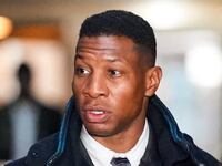 A photo of Jonathan Majors outside court