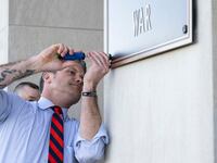 Secretary of War Pete Hegseth finishes the installation of a Department of War plaque at the River Entrance in front of the Pentagon, Washington, D.C., Nov. 13, 2025.
