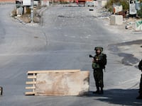 Israeli soldiers have been accused of failing to intervene when Israeli settlers attacked a group of Palestinians in the West Bank.