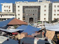 People, including Palestinian children, who fled their house due to Israeli strikes, gather at Al Shifa hospital.
