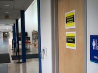 Signs mark a bathroom next to an "isolation room" set up for students or faculty with potential COVID-19 symptoms at Rogers International School on October 21, 2020 in Stamford, Connecticut