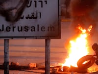 A Palestinian protester sets up a burning barricade near the West Bank city of Ramallah December 8, 2017.
