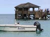 People gather on the resort pier after what police described as a fatal shark attack against a tourist at Sandals Royal Bahamian resort, in Nassau, Bahamas December 4, 2023.