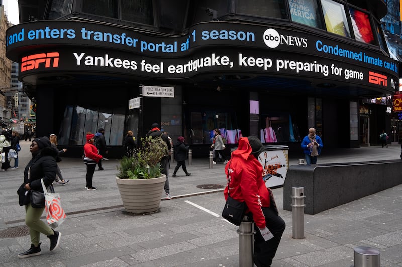 A photo of a digital ticker tape board at Times Square, displaying the news of a 4.8 magnitude earthquake on April 5, 2024 in New York City.
