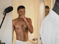 Jerrod Carmichael walks into a hotel shirtless in a still from ‘Jerrod Carmichael Reality Show’