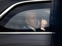 President Joe Biden gives a thumbs-up in a car.