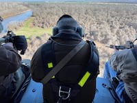 Three hunters aboard a HeliBacon helicopter hunt for feral hogs in Bryan, Texas.