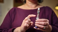 Woman holding a GLP-1 shot of Ozempic