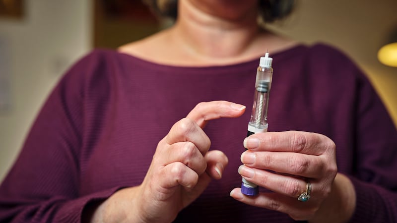 Woman holding a GLP-1 shot of Ozempic