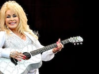 Dolly Parton plays a bedazzled guitar.