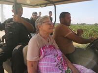 Palestinians transport a captured Israeli Yaffa Adar, center, from Kibbutz Kfar Azza into the Gaza Strip on Oct. 7, 2023.