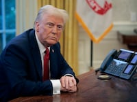 President Donald Trump sits at the Resolute Desk in the Oval Office on Jan. 30.