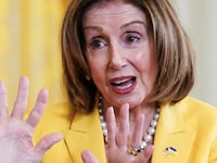 Nancy Pelosi speaks during an event with her hands raised.
