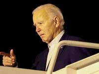 Joe Biden points from the top of stairs to Air Force One