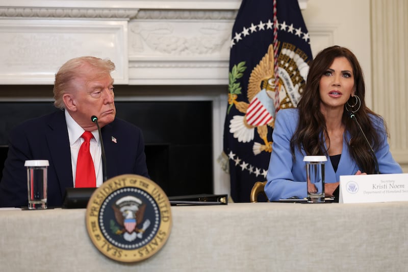 WASHINGTON, DC - OCTOBER 08: U.S. Secretary of Homeland Security Kristi Noem (R) speaks as U.S. President Donald Trump listens during a roundtable discussion in the State Dining Room of the White House on October 08, 2025 in Washington, DC. Trump’s administration held the roundtable to discuss the anti-fascist Antifa movement after signing an executive order designating it as a “domestic terrorist organization”. (Photo by Anna Moneymaker/Getty Images)