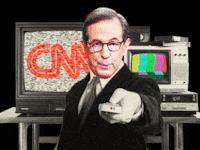 Chris Wallace in front of static TVs with the CNN logo