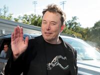 Elon Musk waves as he attends the men's final on day fourteen of the 2024 US Open Tennis Championships