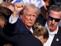 Donald Trump at a rally with blood on his face.