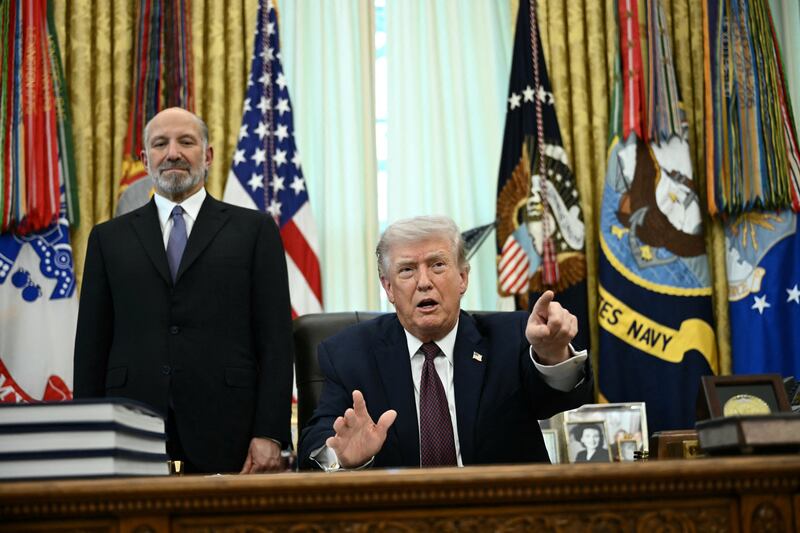 US President Donald Trump (R) speaks as Commerce Secretary Howard Lutnick (L) looks on after signing an executive order in the Oval Office of the White House in Washington, DC, on March 31, 2026. (Photo by Brendan SMIALOWSKI / AFP via Getty Images)