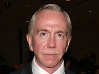 Brent Sikkema, wearing a jacket and tie, stares forward.