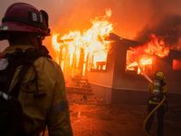 Firefighters work to extinguish the fire as the Palisades Fire burns during a windstorm on the west side of Los Angeles, California, on Jan. 7, 2025.