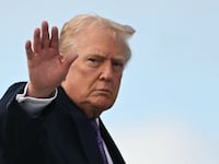 TOPSHOT - US President Donald Trump waves while boarding Air Force One at Palm Beach International Airport on November 30, 2025, on his way back to Washington, DC. President Trump and First Lady Melania Trump spent the Thanksgiving holiday at his Mar-a-Lago residence. (Photo by Jim WATSON / AFP via Getty Images)