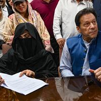 Pakistan's former Prime Minister, Imran Khan (R) along with his wife Bushra Bibi (L) looks on as he signs surety bonds for bail in various cases, at a registrar office in the High court, in Lahore on July 17, 2023.