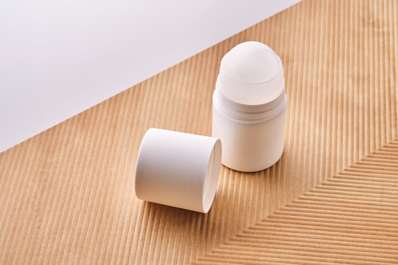 Roll-on deodorant on a background with beige grooves.