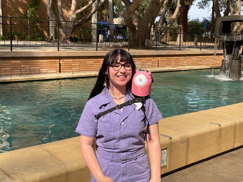 SkoBot inventor Danielle Boyer wears one of her customizable language-teaching devices strapped to her shoulder.
