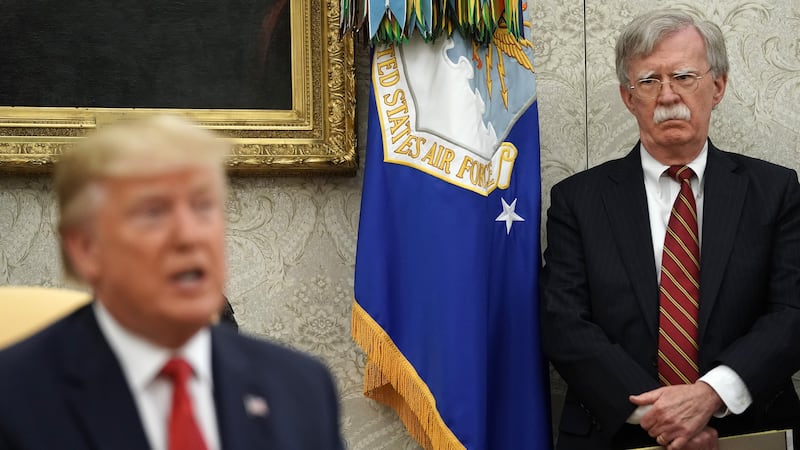 White House National Security Advisor John Bolton (R) listens to U.S. President Donald Trump