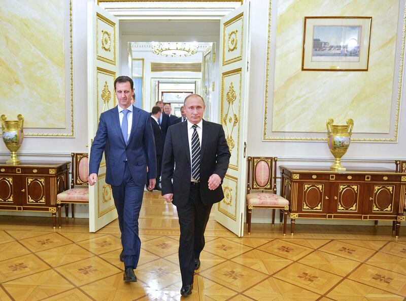 Russian President Vladimir Putin (R) greets his Syrian counterpart Bashar al-Assad upon his arrival for a meeting at the Kremlin in Moscow on October 20, 2015. Assad, on his first foreign visit since Syria's war broke out, told his main backer and counterpart Putin in Moscow that Russia's campaign in Syria has helped contain "terrorism". (Photo by ALEXEY DRUZHININ / RIA NOVOSTI / AFP) (Photo by ALEXEY DRUZHININ/RIA NOVOSTI/AFP via Getty Images)