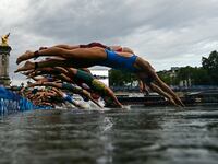 The women dive into the Seine at the start of the triathlon