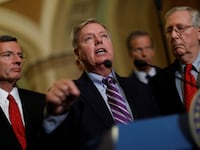 Sen. Lindsey Graham (R-SC), accompanied by Sen. John Barrasso (R-WY), and Senate Majority Leader Mitch McConnell, speaks with reporters following the party luncheons on Capitol Hill in Washington, U.S., September 19, 2017.