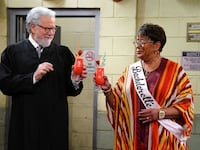 John Larroquette stands in a judge robe and cheers Marsha Warfield in a still from ‘Night Court’