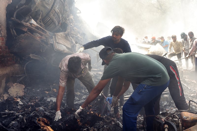 Rescue officials work at the site where Air India flight 171 crashed in a residential area near the airport in Ahmedabad on June 12, 2025.