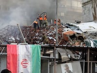 Emergency and security personnel extinguish a fire at the site of strikes which hit a building annexed to the Iranian embassy in Syria's capital Damascus, on April 1, 2024.