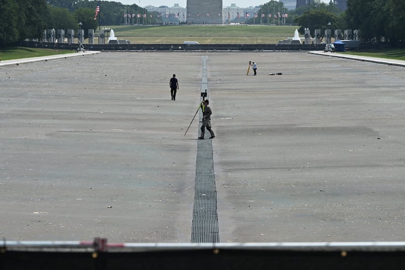 Surveyors work at the Lincoln Memorial Reflecting Pool on the National Mall in Washington, DC on July 15, 2026. US President Donald Trump said, on July 13, the newly renovated Reflecting Pool in Washington was drained for repairs, after the project has faced a series of setbacks, including alleged vandalism. The renovation of the pool next to the US capital's Lincoln Memorial is a pet project of Trump's, but the remodel has been dogged by the growth of algae and peeling paint which the president alleges is the work of vandals. "We drained the beautiful 'Reflecting Pool' today in order to fix the scars and damage that was done by the Vandals two weeks ago," Trump wrote on his Truth Social platform late Monday, adding that they waited until after the July Fourth holiday to drain the pool.