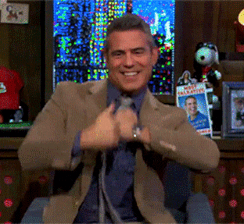 Gif of Andy Cohen doing a happy dance with thumbs up