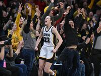 Iowa Hawkeyes guard Caitlin Clark reacts with fans after breaking the NCAA women's all-time scoring record.