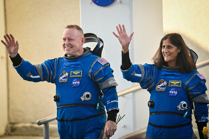 NASA astronauts Butch Wilmore (L) and Suni Williams, wearing Boeing spacesuits, wave as they prepare to depart the Neil A. Armstrong Operations and Checkout Building at Kennedy Space Center for Launch Complex 41 at Cape Canaveral Space Force Station in Florida to board the Boeing CST-100 Starliner spacecraft for the Crew Flight Test launch, on June 5, 2024. Boeing on June 5 will try once more to launch astronauts aboard a Starliner capsule bound for the International Space Station. Liftoff is targeted for 10:52 am (1452 GMT) for a roughly one-week stay at the orbital laboratory. (Photo by Miguel J. Rodriguez Carrillo / AFP) (Photo by MIGUEL J. RODRIGUEZ CARRILLO/AFP via Getty Images)