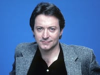 A portrait of Star Trek actor James Sloyan against a blue background.