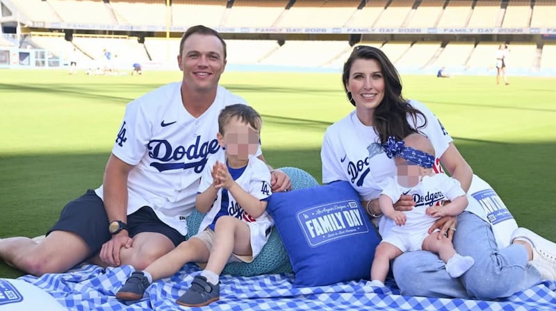 Dodgers outfielder Alex Call is pictured with his family on the Dodgers' home field, with his children's faces blurred for social media use.