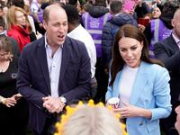 The Prince and Princess of Wales speak with the public during an event.